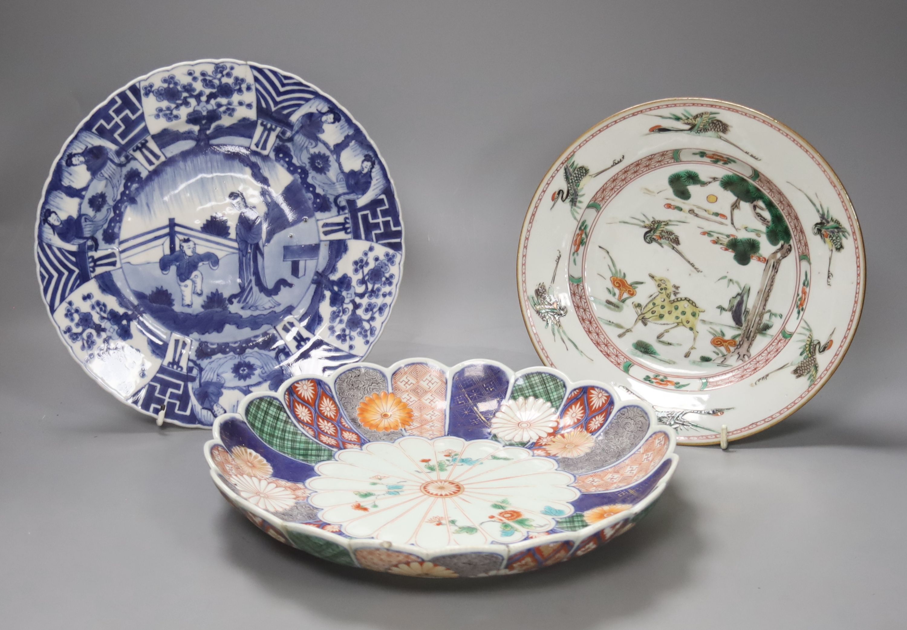A Chinese Kangxi famille verte plate, decorated with a deer, a 19th century Chinese blue and white plate and an Imari scalloped dish, c.1850